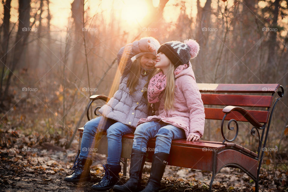 Two sibling sitting on bench
