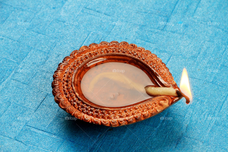 Indian festival Diwali diya oil lamp on blue background