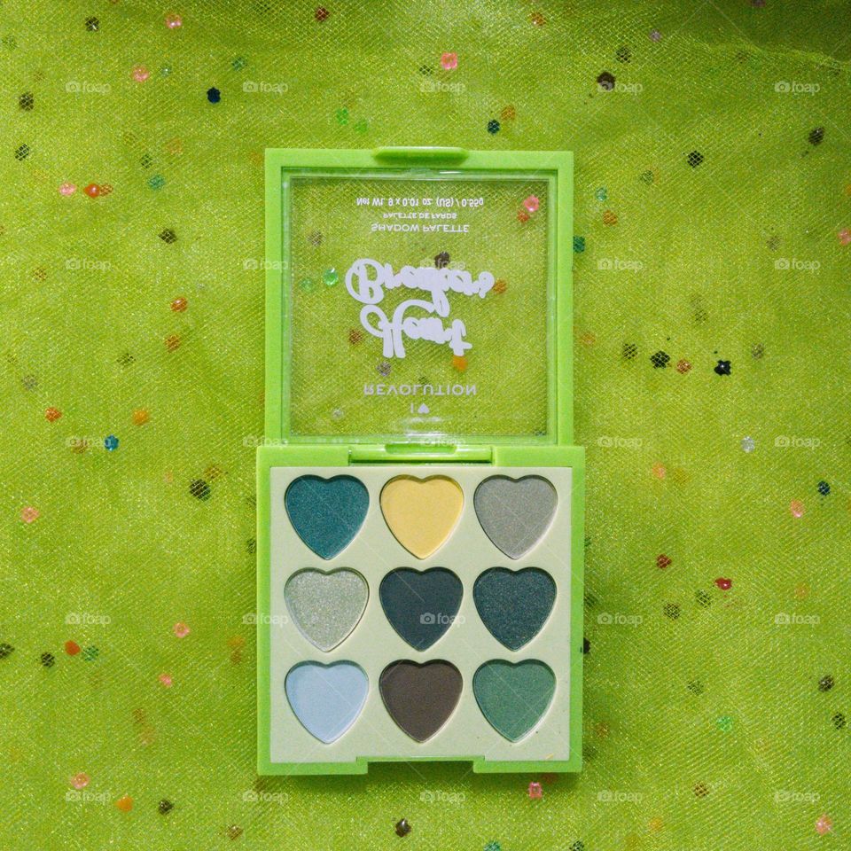 A neon green eyeshadow palette, with various bright and neutral colors.