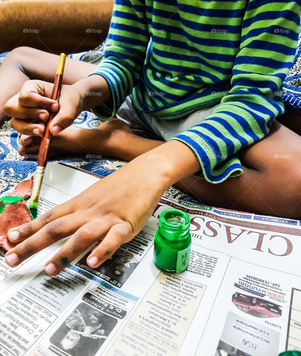 Kid doing a craft with paper and paint