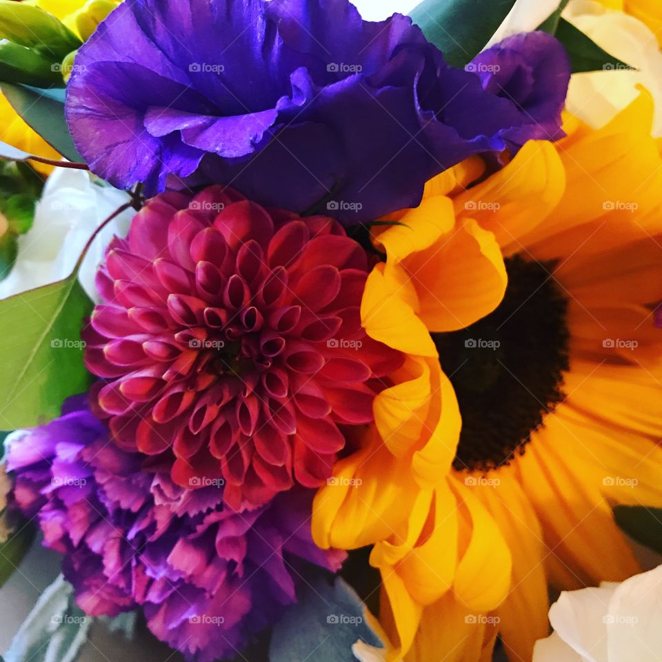 A bright and colorful fall bouquet of flowers ready to walk down the aisle with a bridesmaid. 