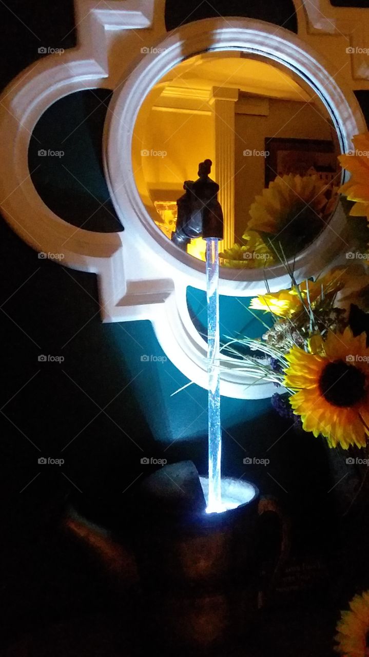 artificial light vs natural light water fountain on table with flowers and mirror