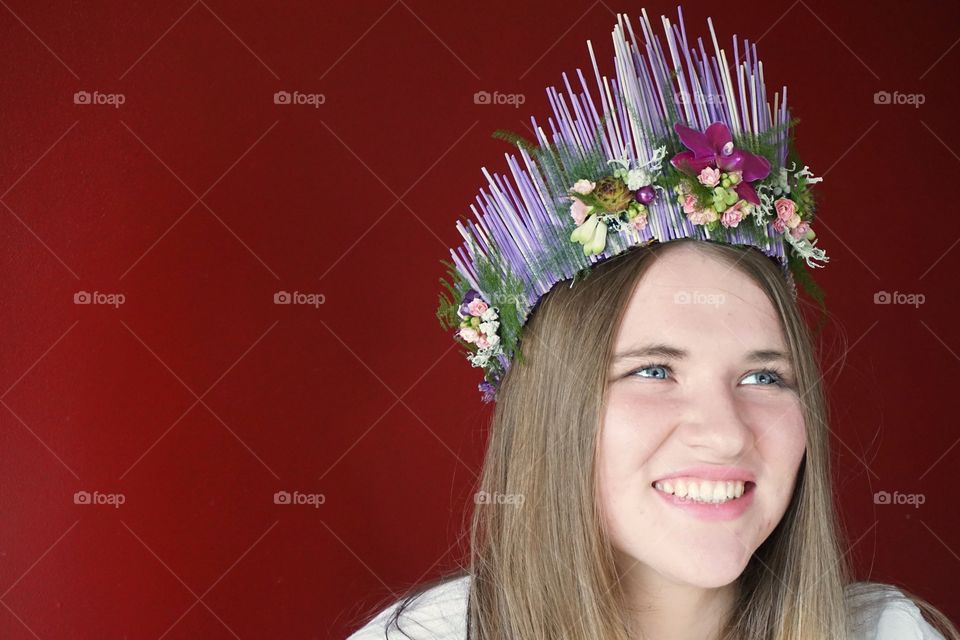 Woman wearing crown with red background