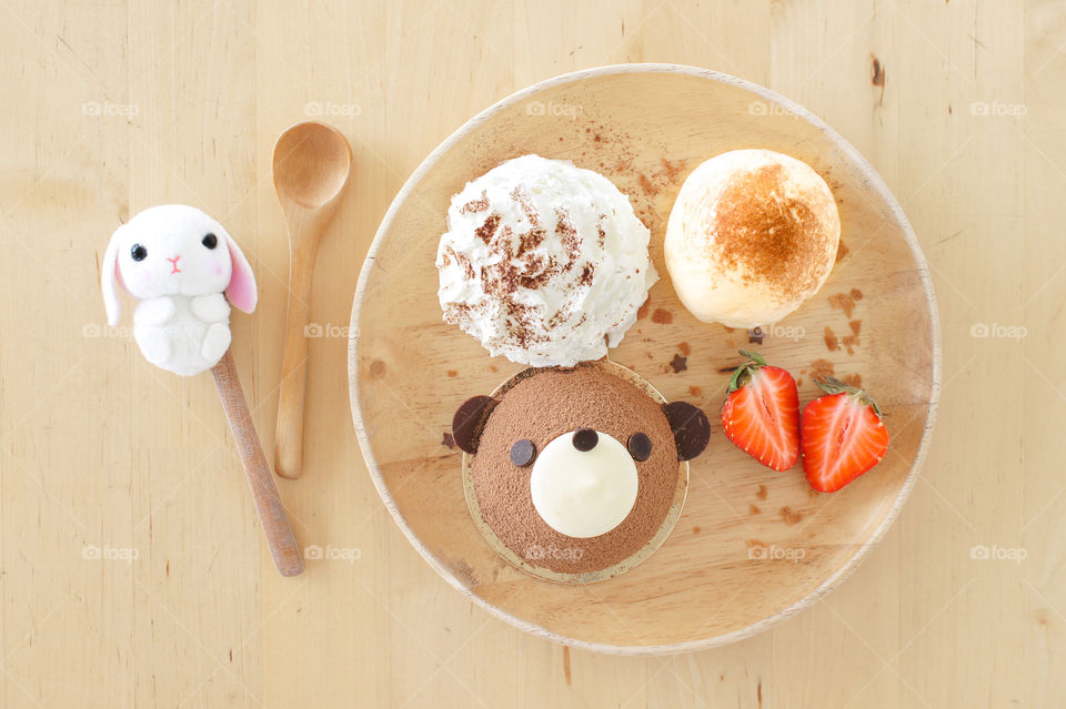 Teddy bear chocolate cake on the wooden dish and wooden table, too view. Cute food. Birthday cake