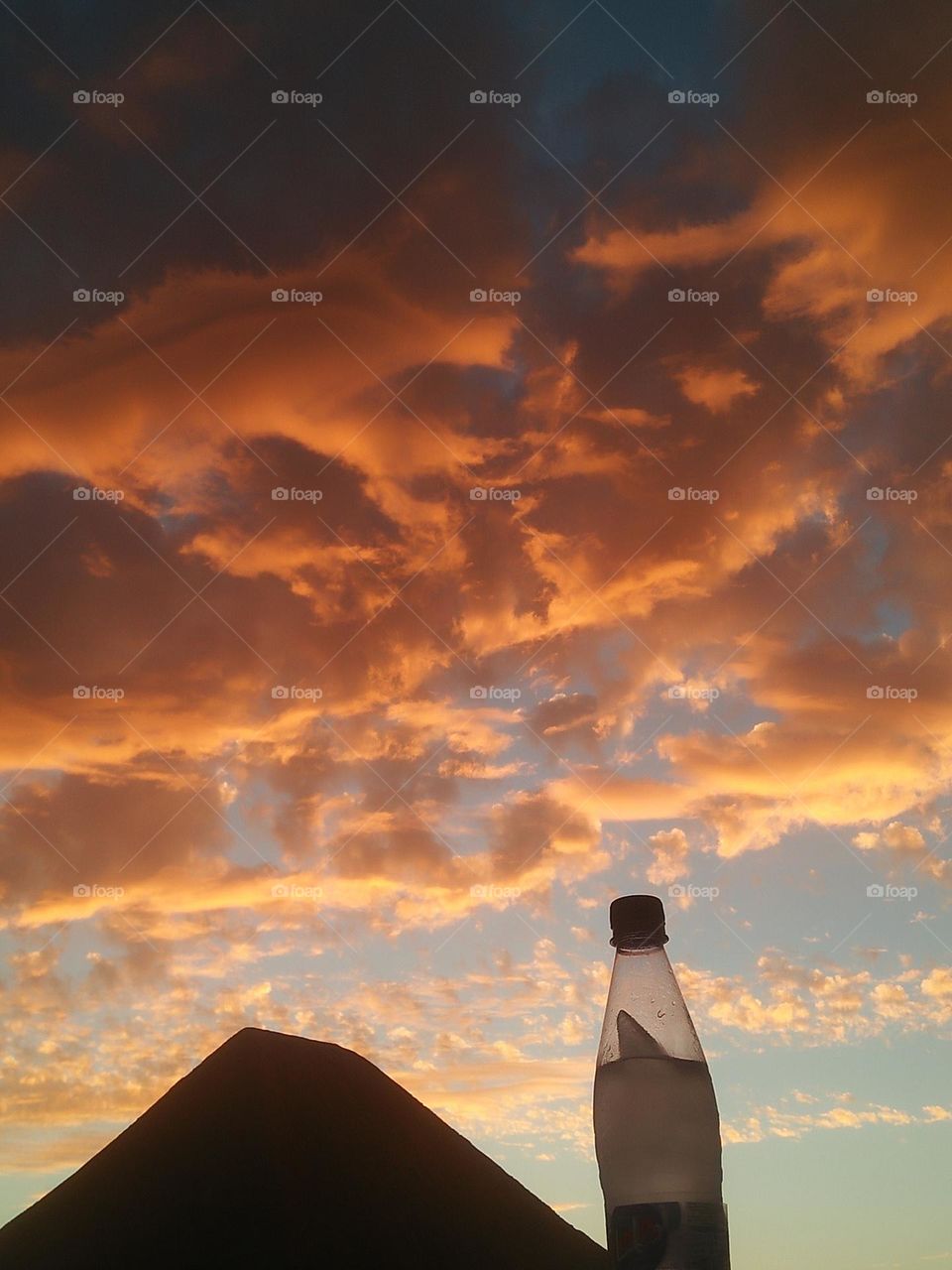 Magic sunset and a beautiful bottle embraces high sky.