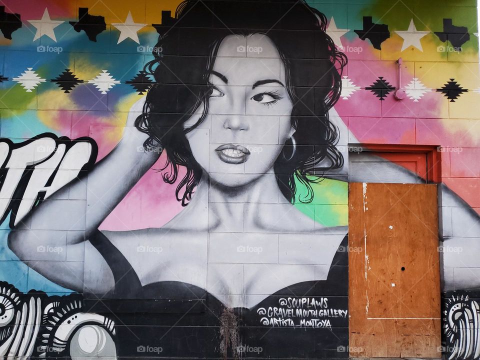 Street art. Her facial expression is one that can be interpreted as being disgusted with what she is looking at.