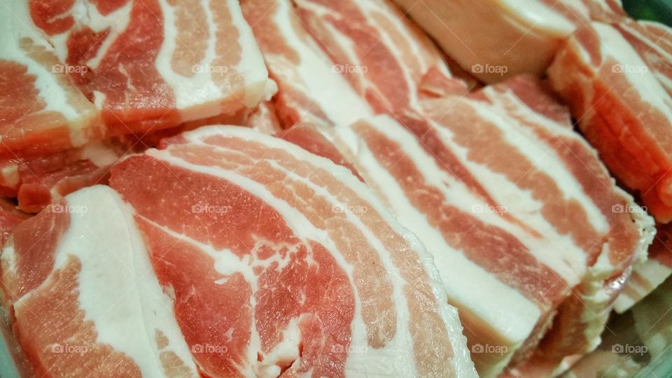 Pork neck meat freshly sliced into thin portions ready for various methods of cooking. Popular on barbecues in Korean cuisine.