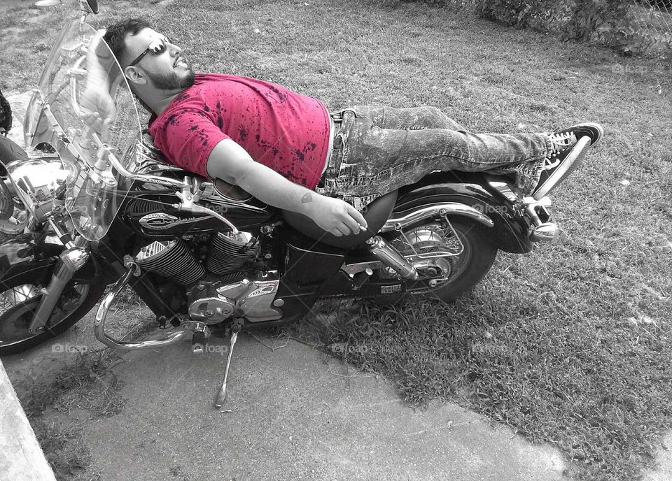 man laying down and relaxing on motorcycle