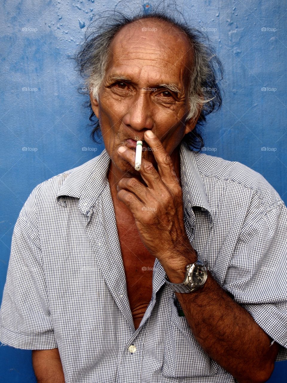 old asian man. old asian man smoking a cigarette