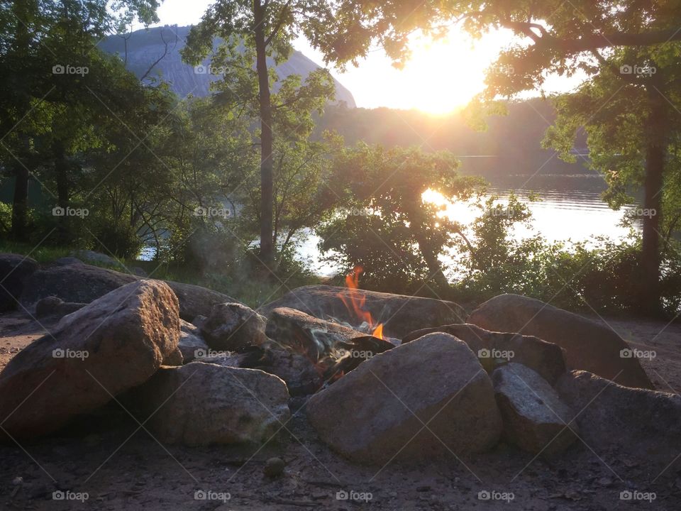 Camp fire in the woods by a lake