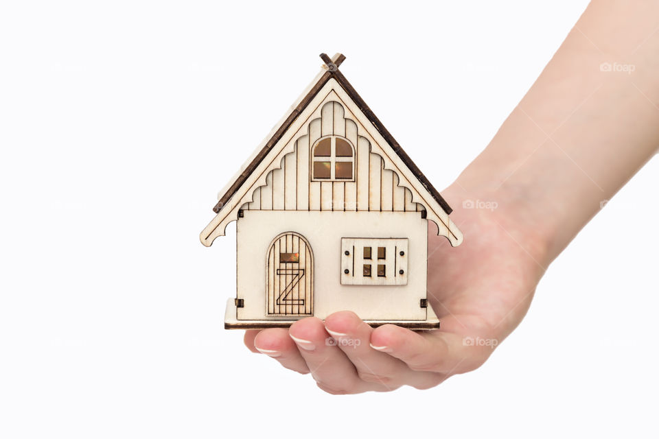 toy house in hand on a white background