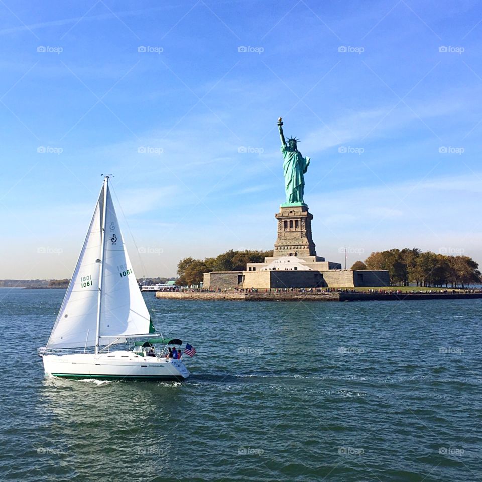 Statue of Liberty with a perfectly times sailor next to her! (Taken October 2015) Beautiful boat ride to the statue and definitely worth the trip!