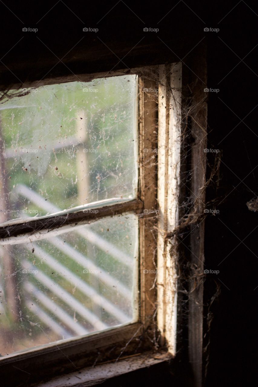 View through a cobweb-covered window from a hayloft 