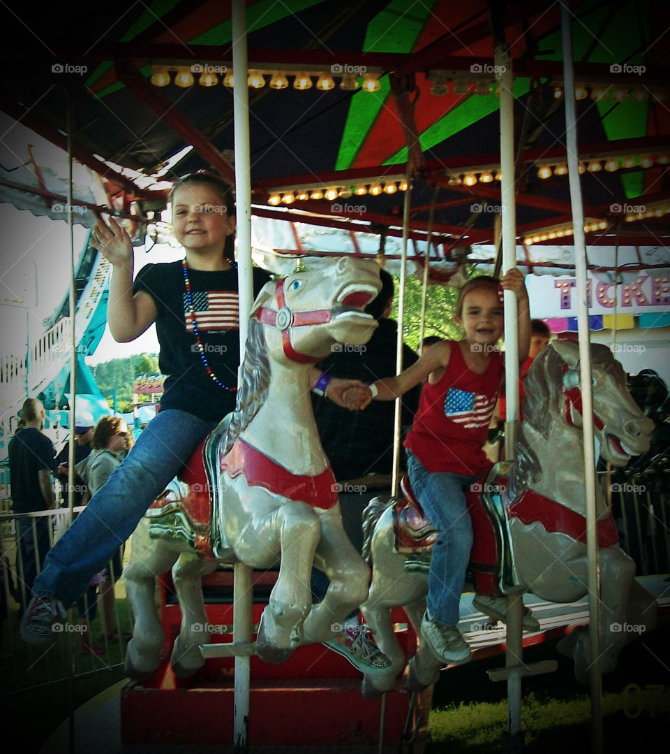 Cousins on a Merry-Go-Round on At a 4th of July Carnival