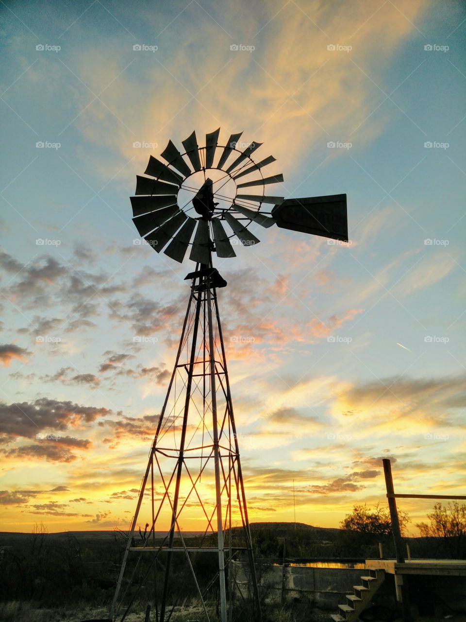 a windmill silhouetted against a west Texas sunset