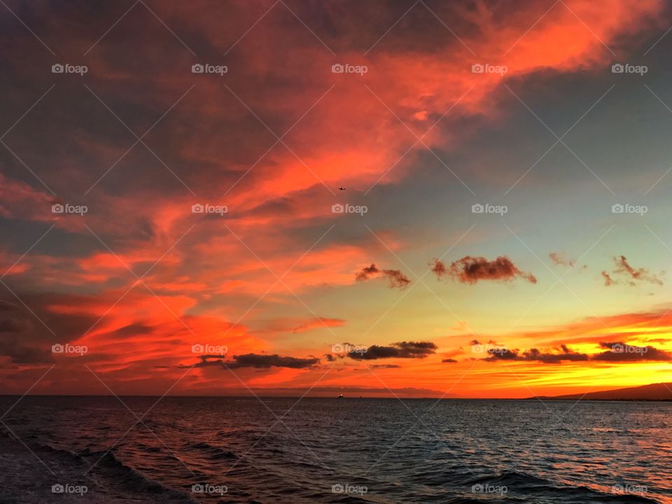 Beautiful sunset of Hawaii from out at sea with the reflection on the ocean 