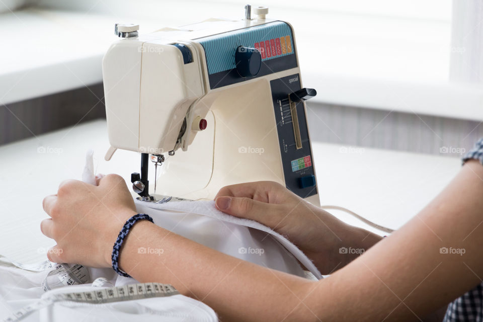 Girl learns to sew on the sewing machine