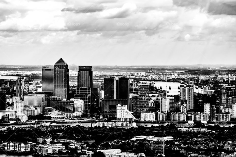 A black and white photograph of the Canary Wharf area of London, England.