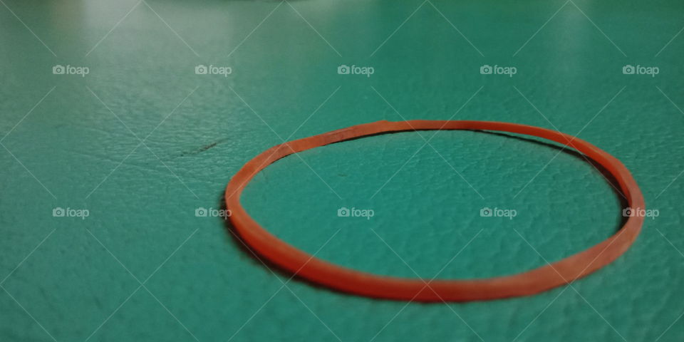 Circular rubber band on green table with close up view