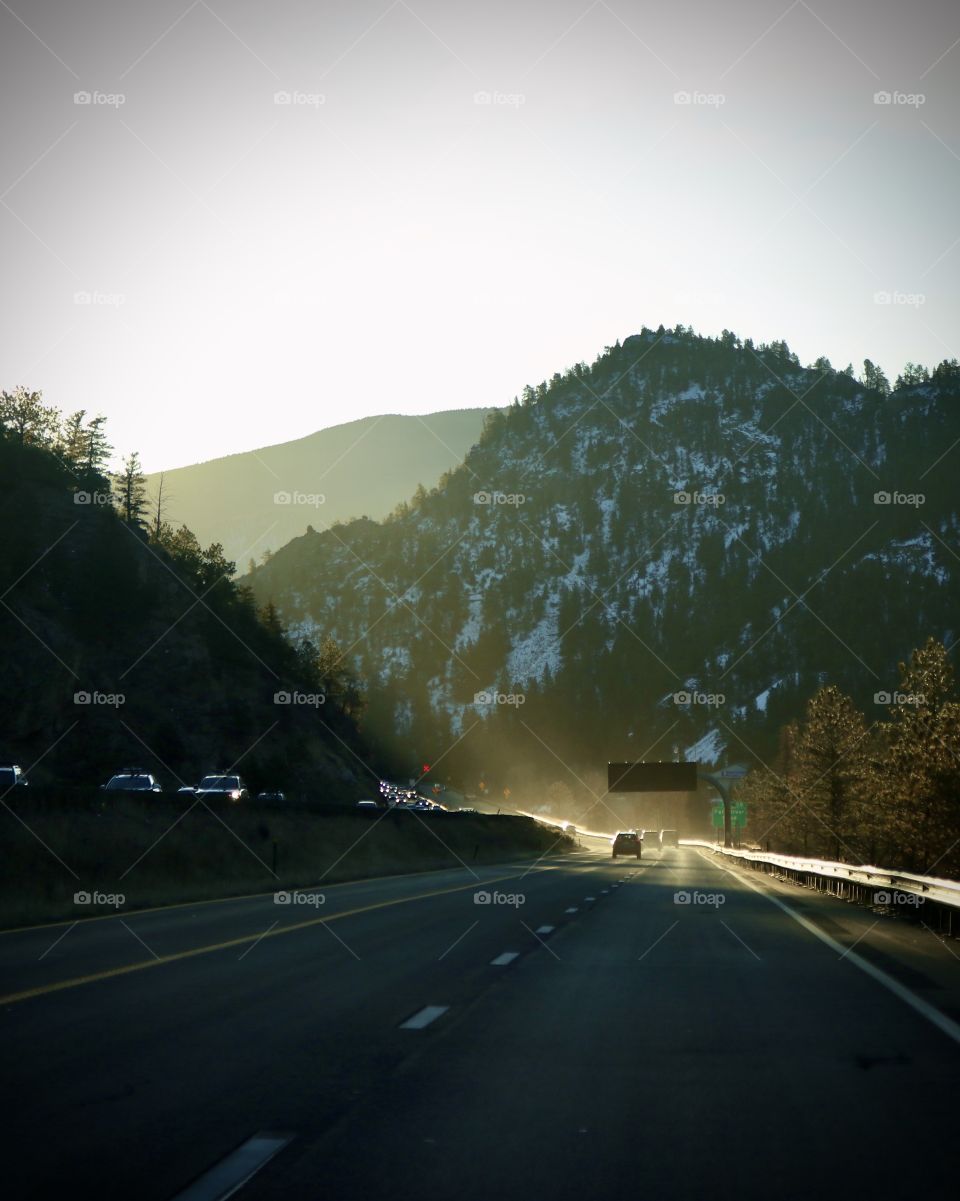Golden sunlight streaming down on the pass through the mountains.