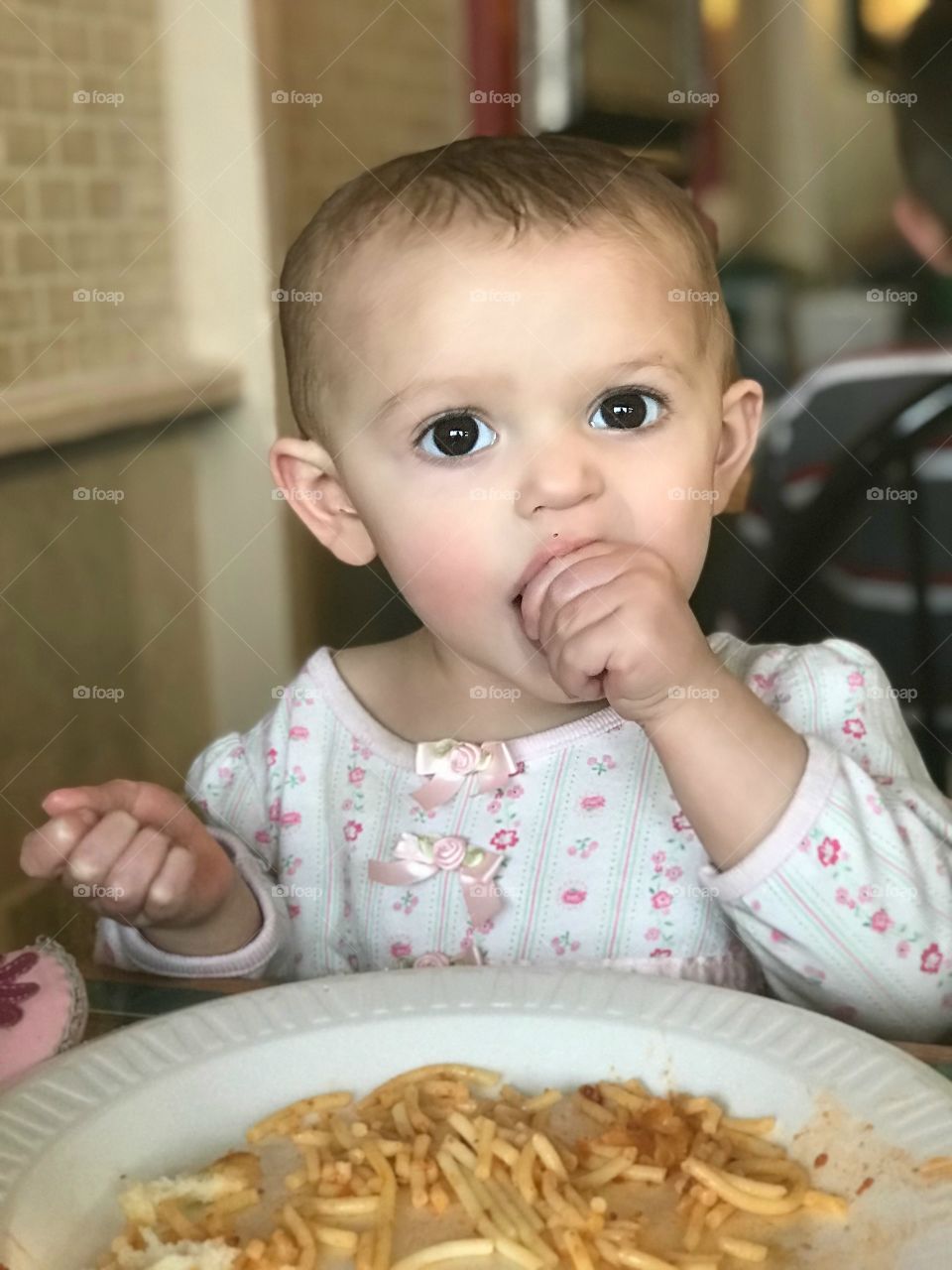 Baby enjoying spaghetti! In this photo, baby girl enjoys her very first bowl of spaghetti, something that she consumes with great relish. :)