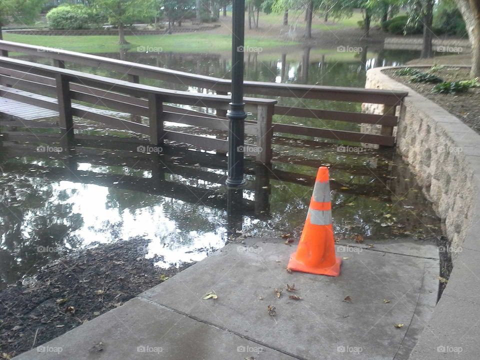 Lake overflow guarded by traffic cone