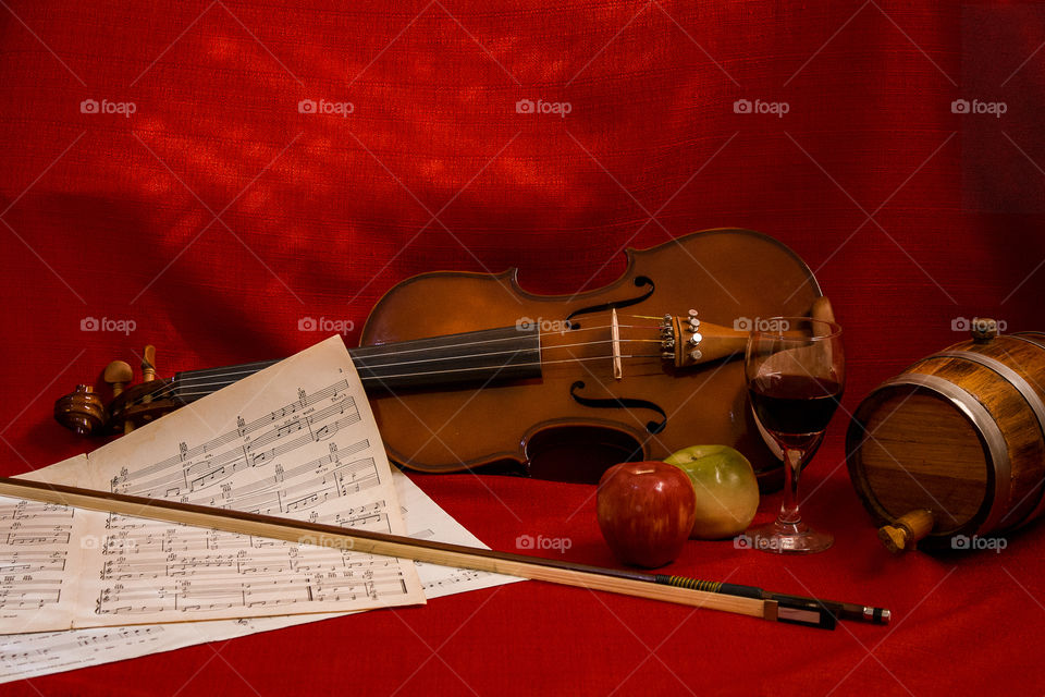 Still life picture, with violin, apple and wine.