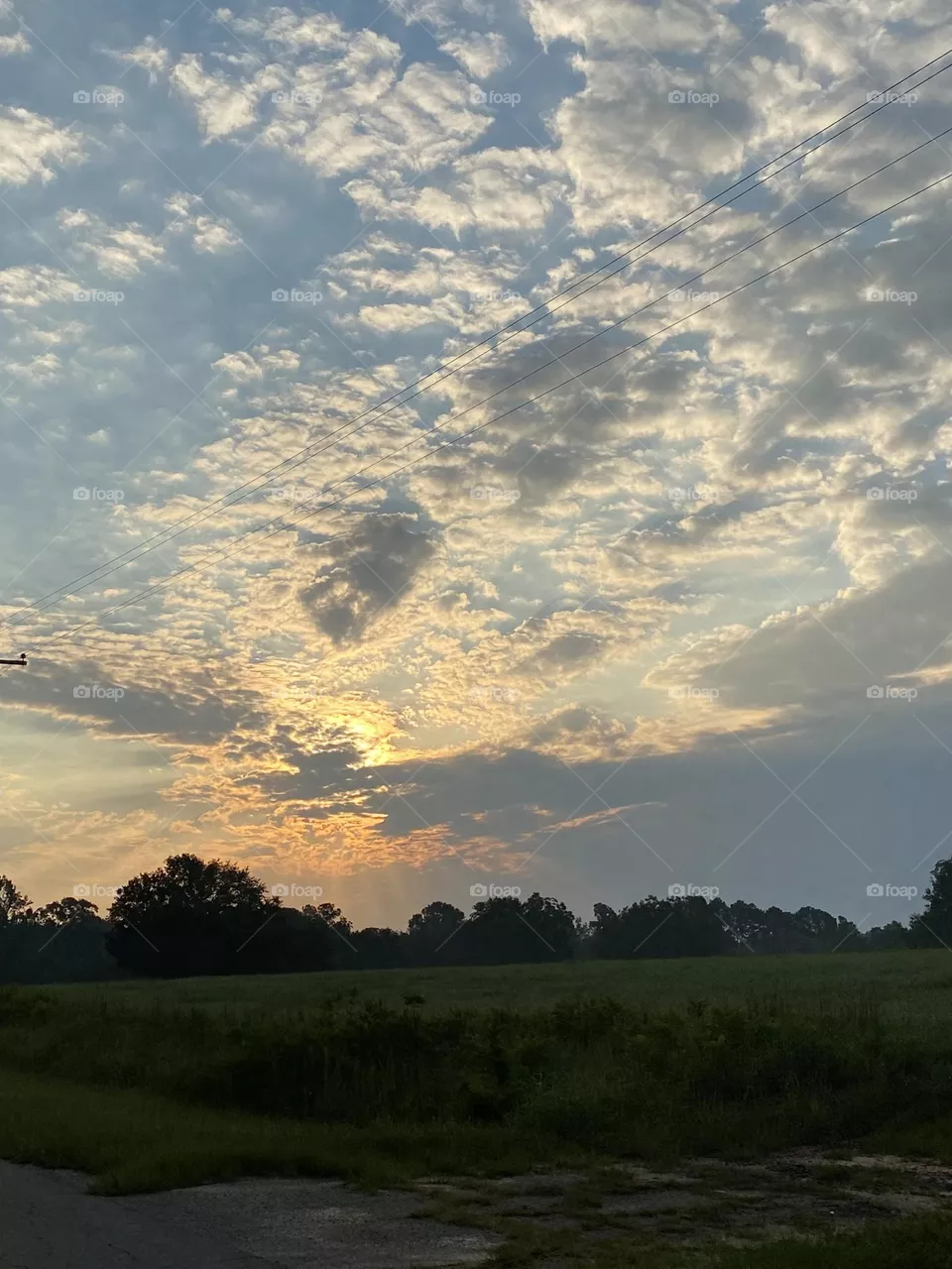 Look at the beautiful sky with sun behind it 