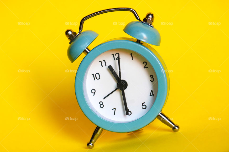 Blue clock on a yellow background
