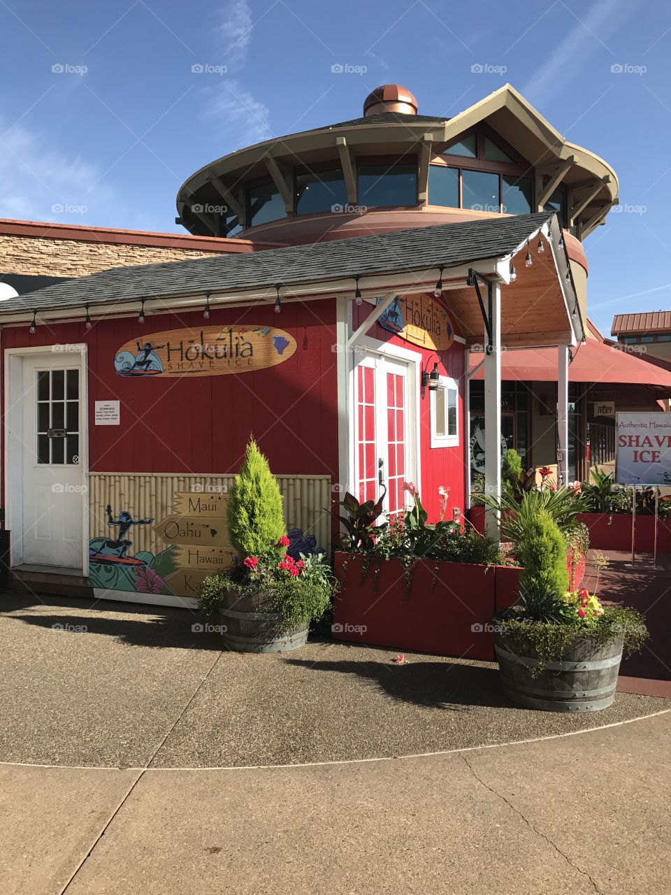 Small red Hawaiian shaved ice shack on a sunny day with blue sky in the background