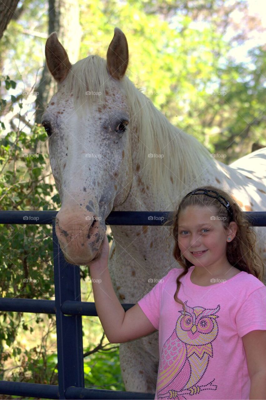 Little girl standing with horse