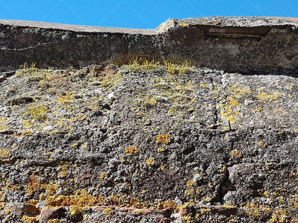 Ancient stone wall against blue sky