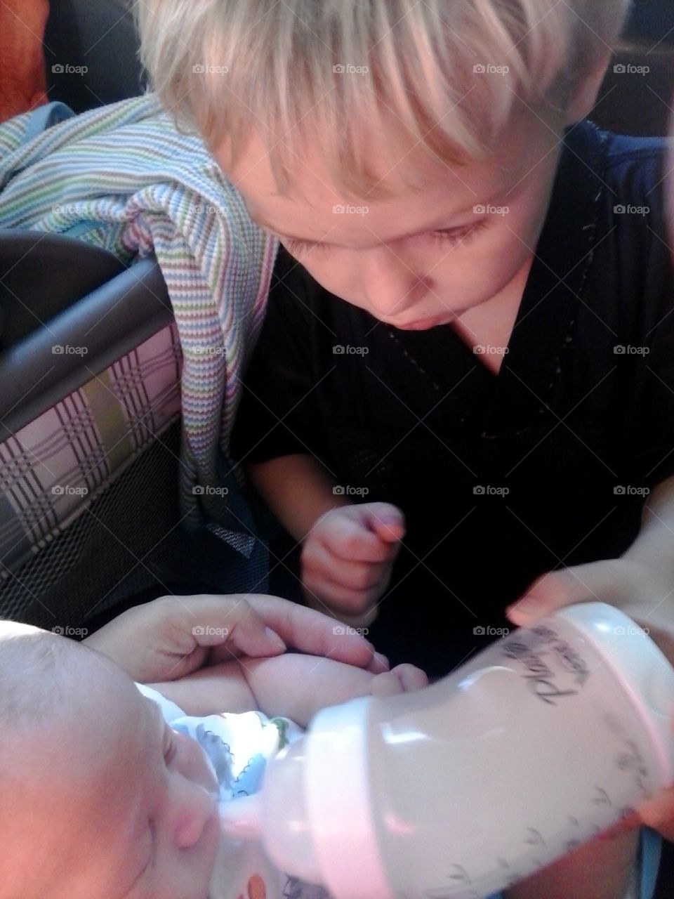 Gavy and Faron . Gavin is helping feed his new brother 