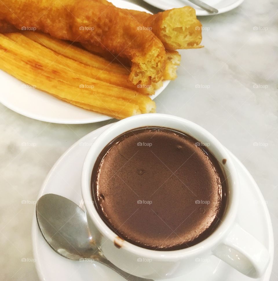 Cup of hot chocolate and fresh porra on a marble table
