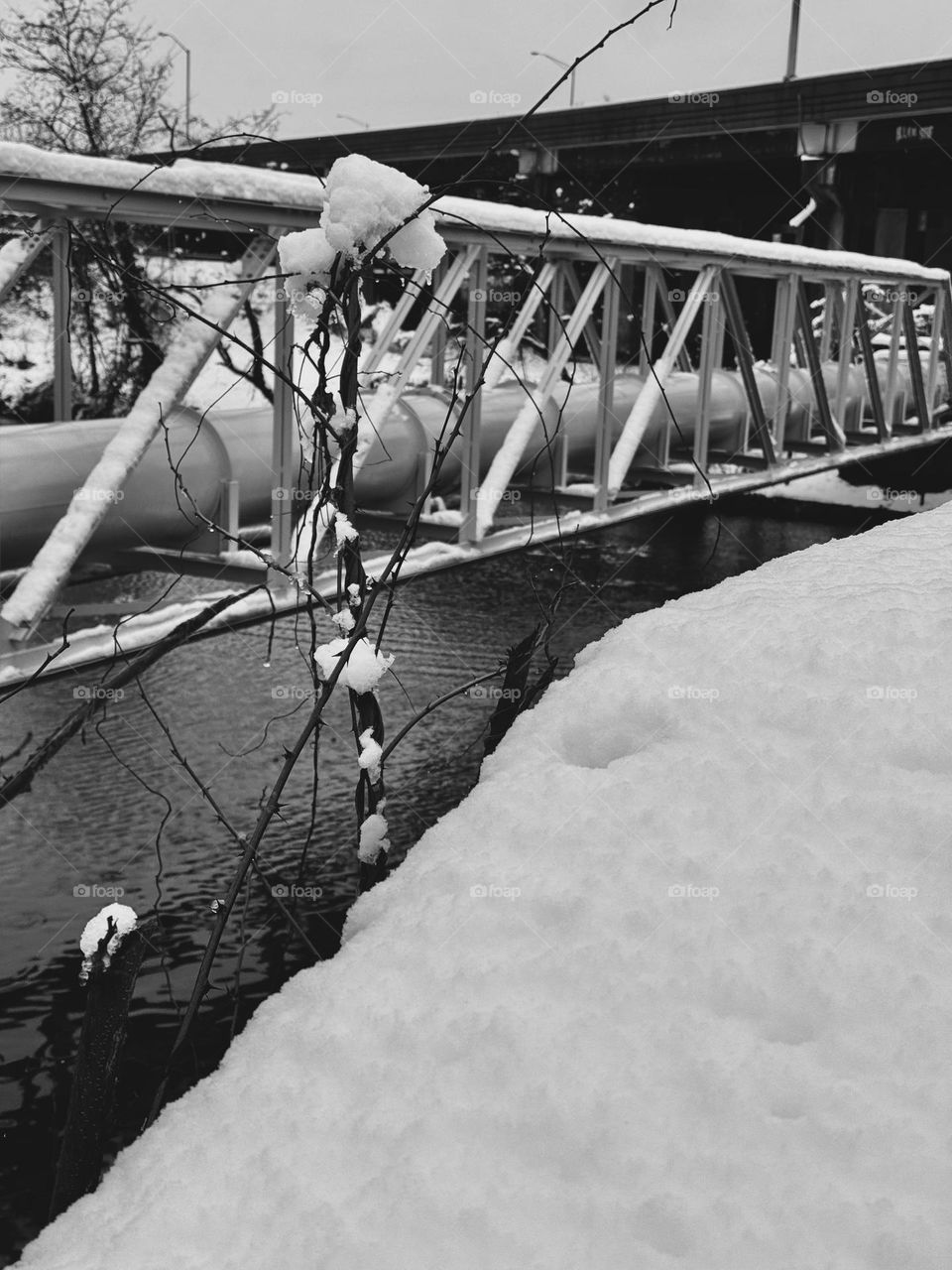 Snow covered structure spanning a tributary of the CT river in black and white