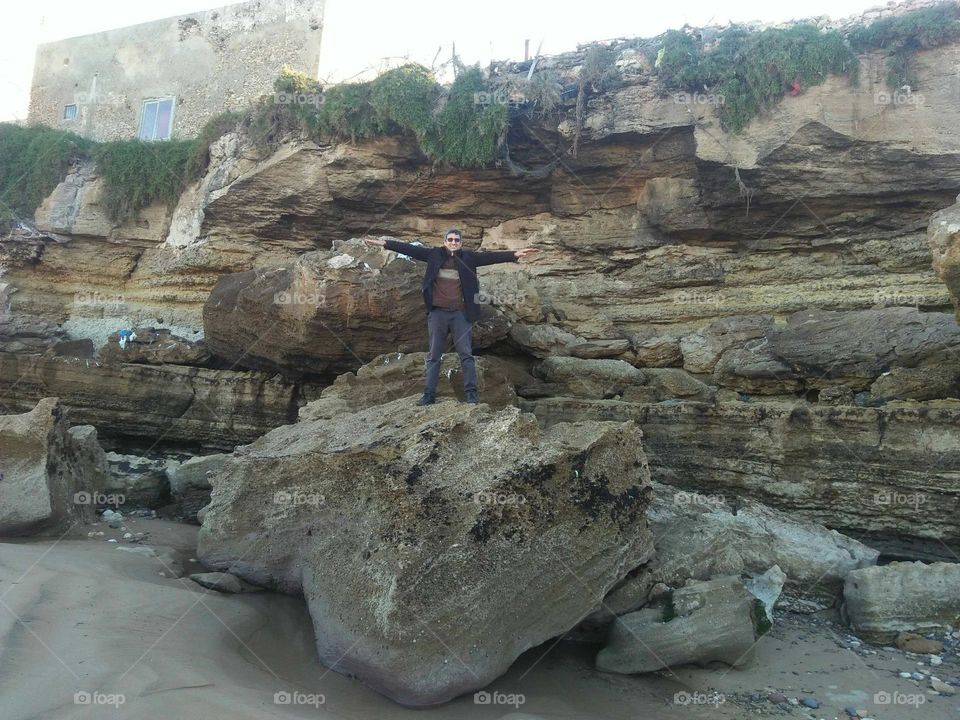 Im standing alone on a big rock near the beach at essaouira in Morocco.