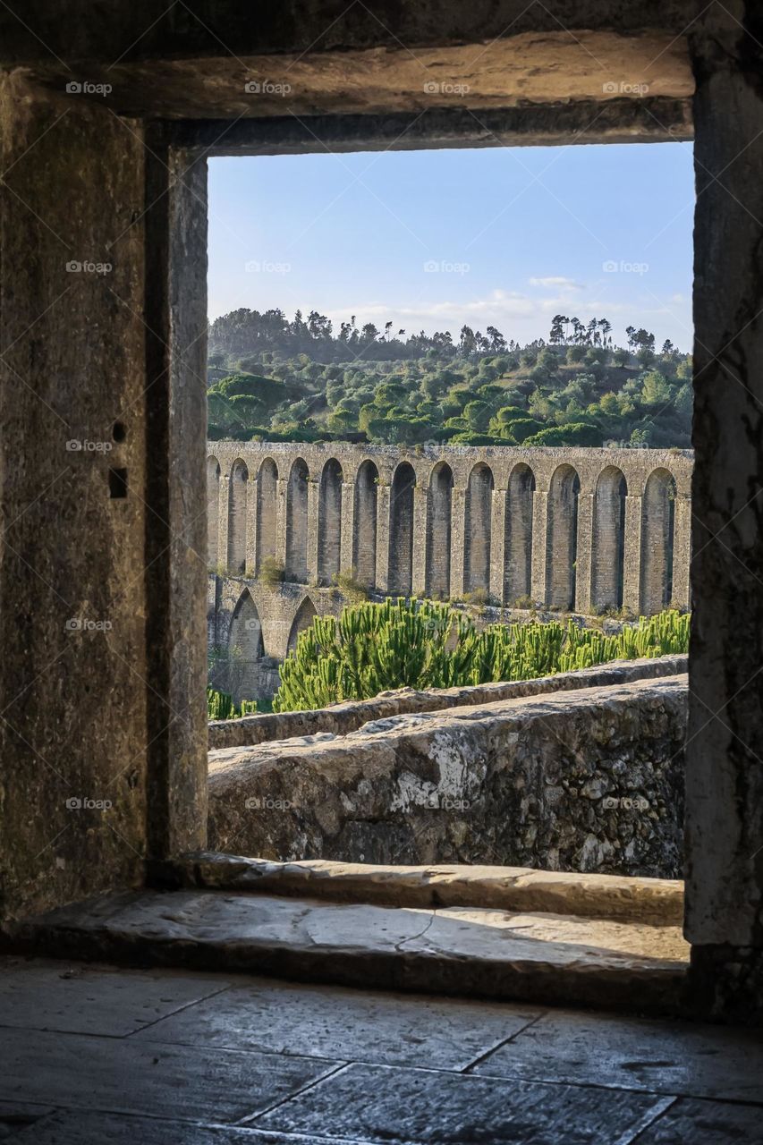 A view of Pegões Aqueduct through the stone window of its tower in Tomar. 