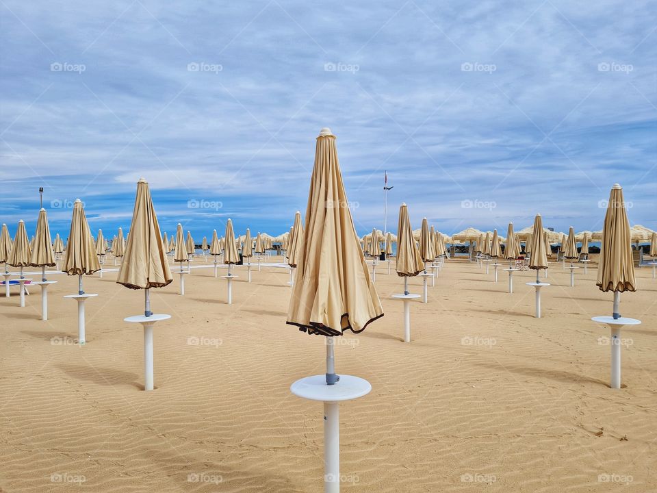 background with closed sea umbrellas on the beach