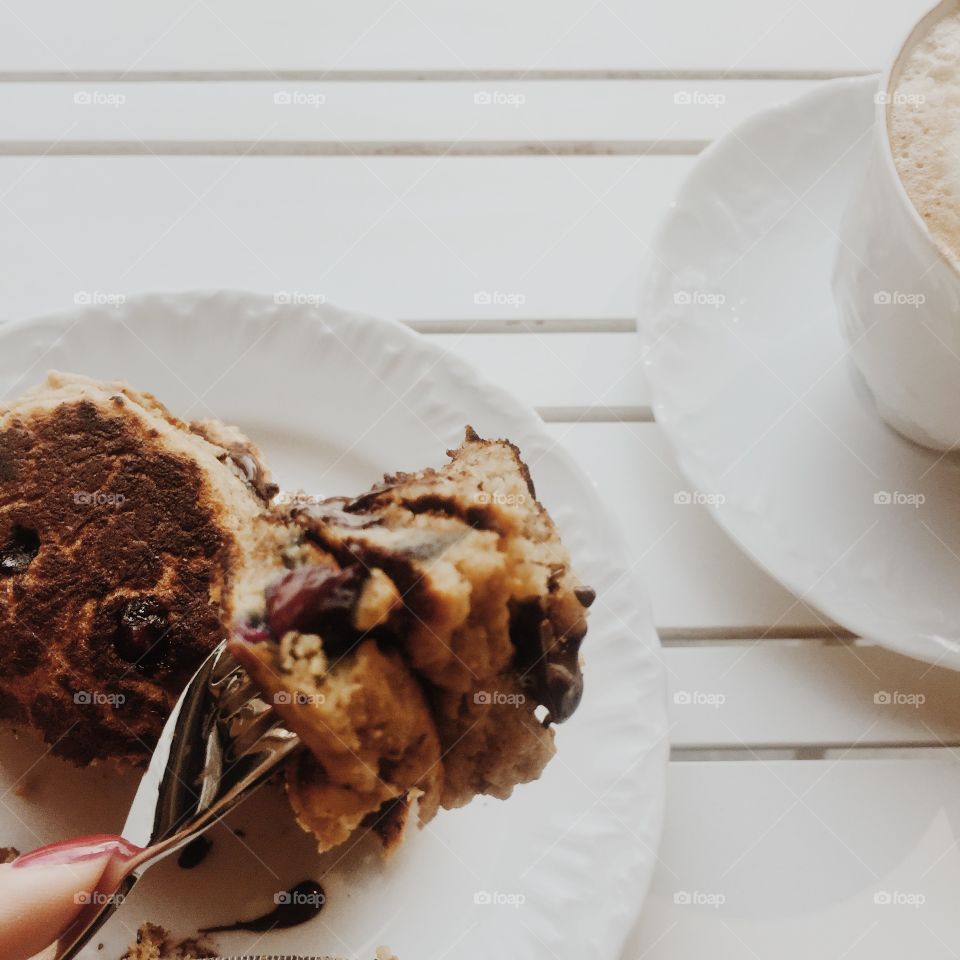 Person's finger with fork and pancake