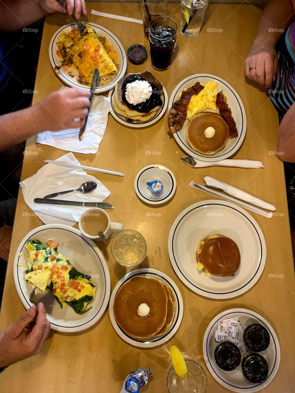 Top view of the table for breakfast including eggs pancakes bacon juice coffee creamer