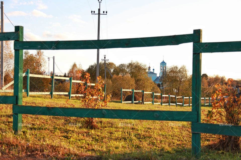 fence and view of the church  landscapes and trees in colorful outfits