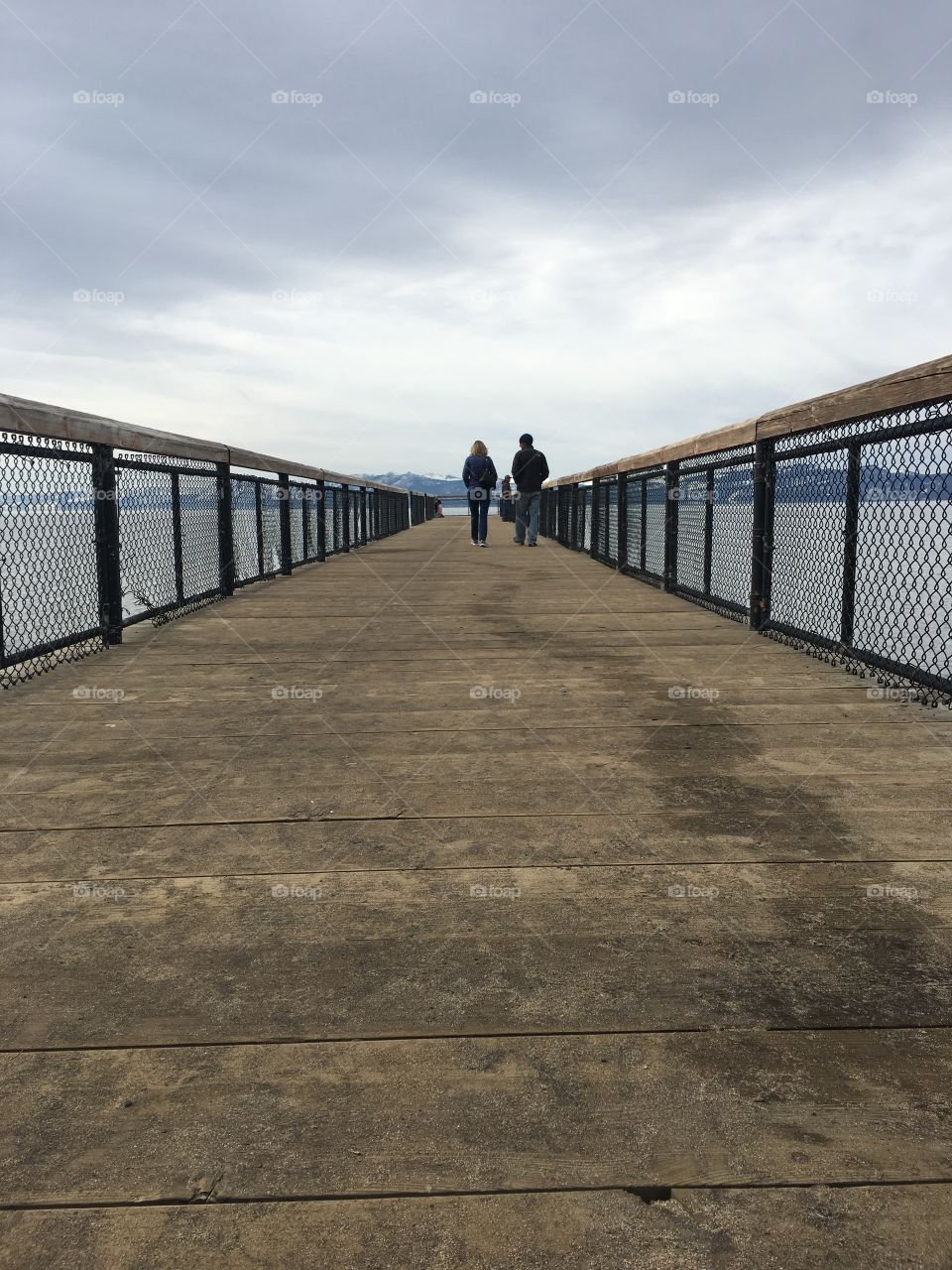 Couple walking down pier