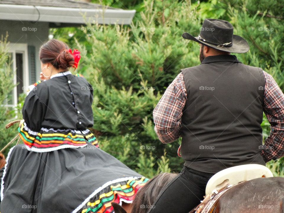 Mexican Scene. Married Couple On Horseback In Festive Western Costumes
