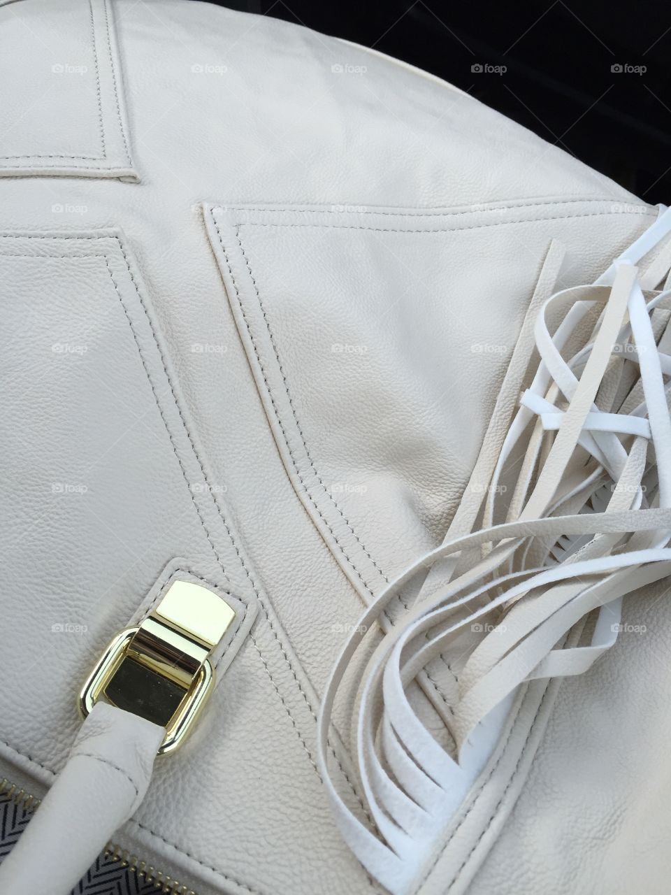 Fringe handbag closeup details. Ivory Handbag closeup of hardware and fringe details. 