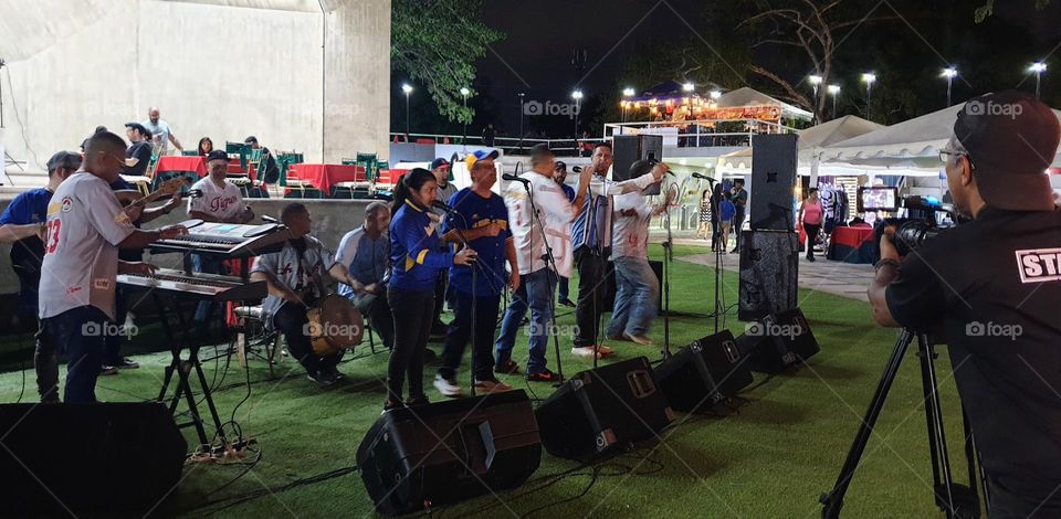 cameraman recording a bagpiper concert in the Concha Acústica tourist place in Maracay Venezuela