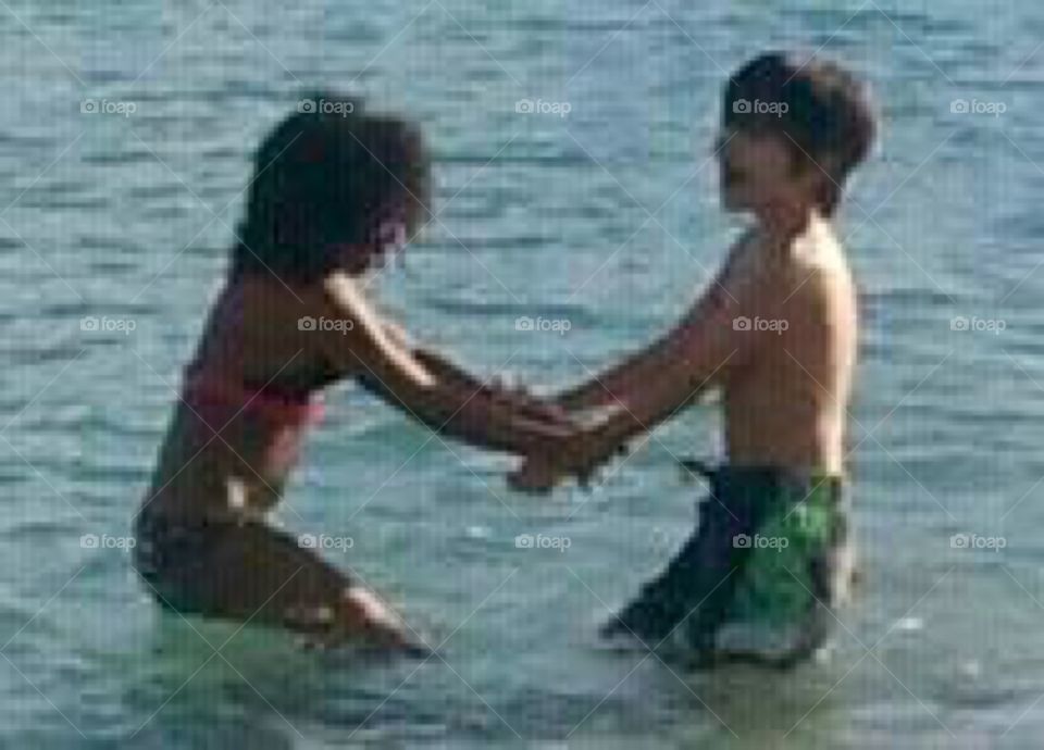 Children playing in ocean 