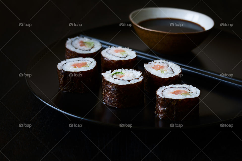 Homemade sushi on black plate