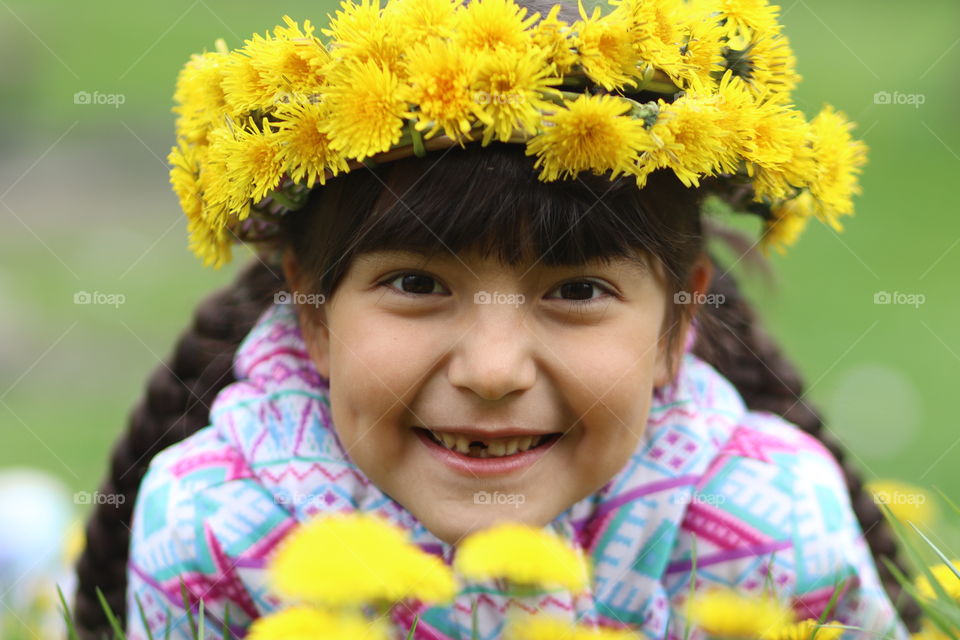 Cute little girl with yellow dandelions