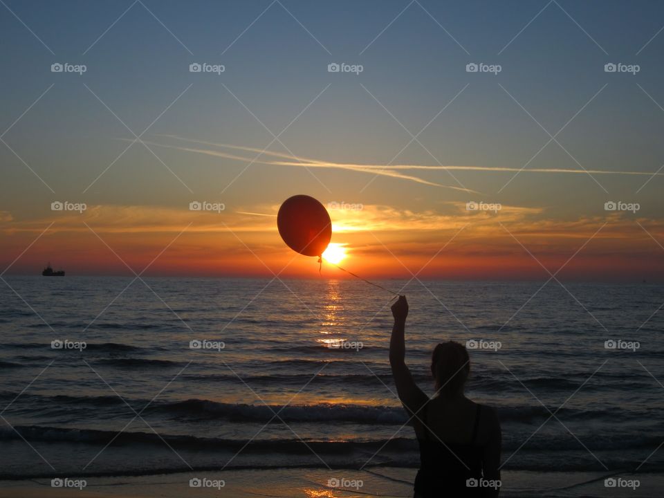 Balloon and sunset. A woman holding beautiful balloon on the sun
