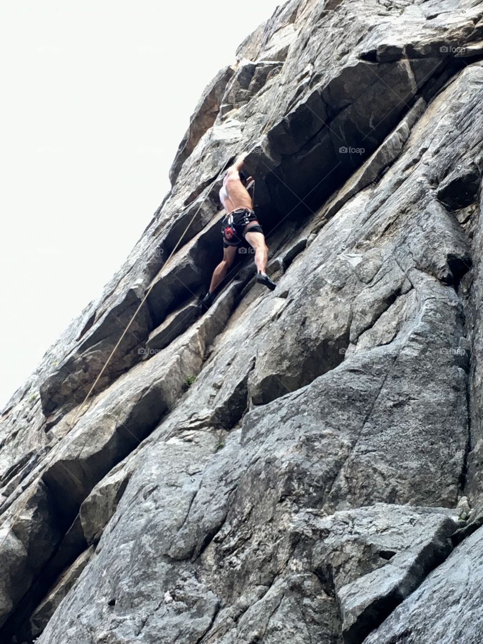 Climber on a rock ledge on the face of a mountain 
